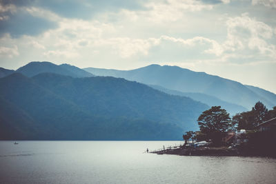 Scenic view of sea and mountains against sky