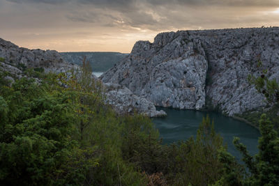 Scenic view of river and cliff against sky