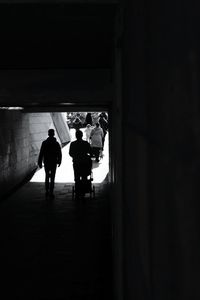 Rear view of silhouette people walking in corridor of building
