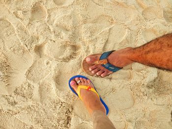 Low section of man relaxing on sand