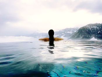 Man swimming in sea against sky