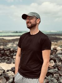 Portrait of young man standing at beach