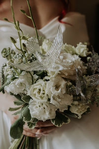 Midsection of woman holding white flowering plant