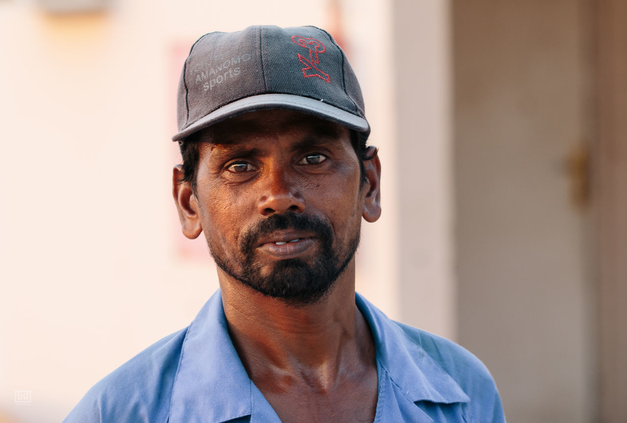 real people, portrait, cap, one person, looking at camera, day, young adult, close-up, outdoors