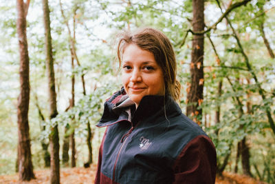 Portrait of smiling woman standing in forest