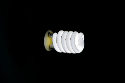 Close-up of illuminated light bulb against black background