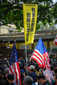 Group of people in front of flags in city