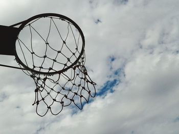 Low angle view of basketball hoop against cloudy sky