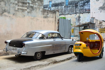 Vintage car on street against buildings in city