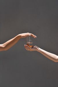 Close-up of hand holding glass against black background