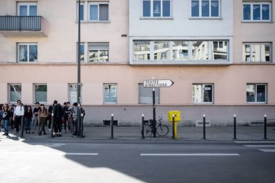 People on street against buildings in city