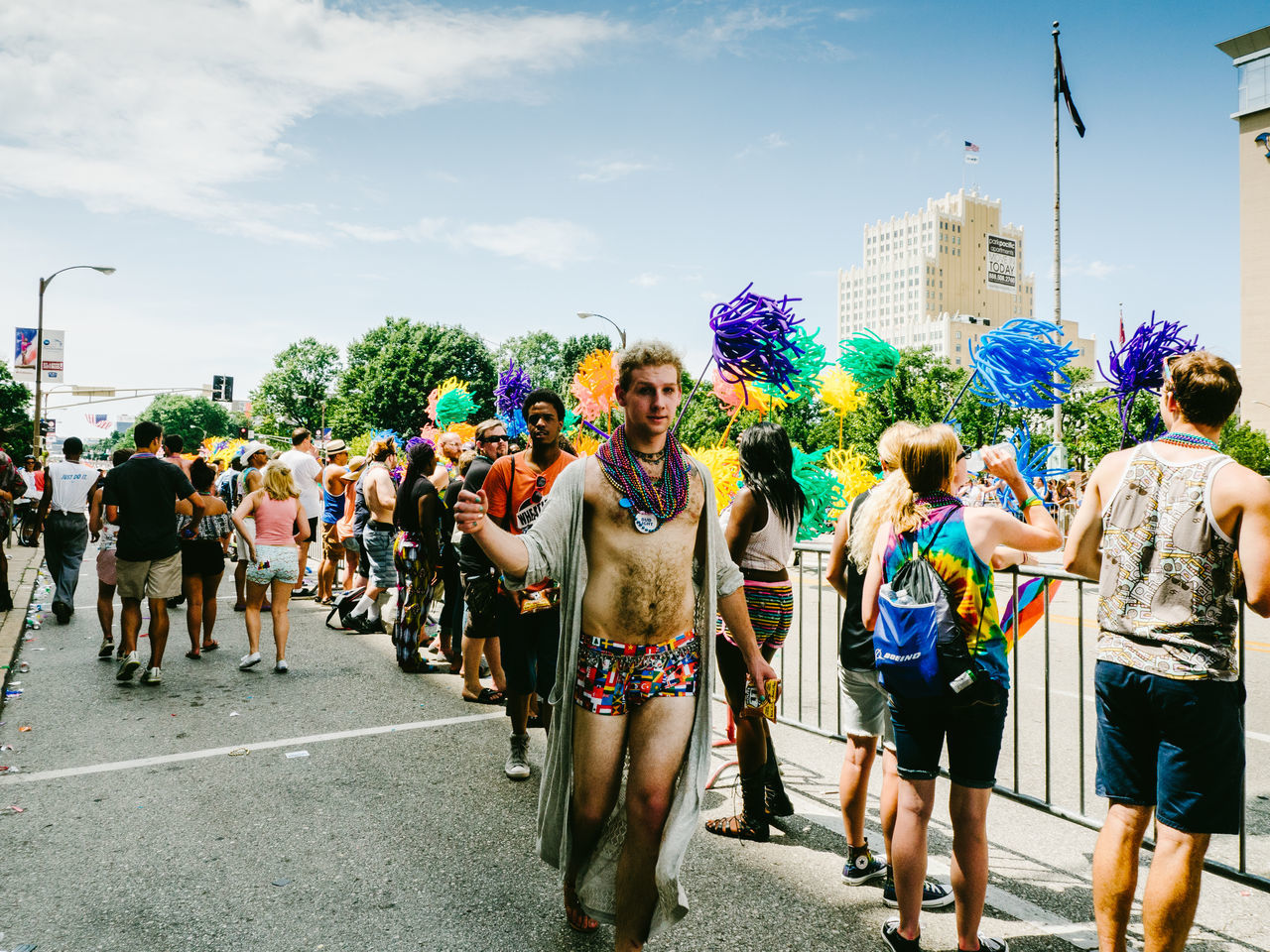 large group of people, person, lifestyles, men, street, leisure activity, walking, crowd, road, sky, mixed age range, celebration, multi colored, city life, casual clothing, city, building exterior, day, umbrella