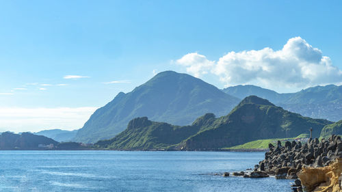 Scenic view of sea and mountains against sky