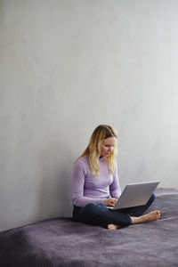 Woman on bed using laptop