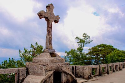 Cross against clear sky at cemetery