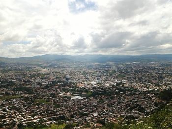 High angle view of cityscape against cloudy sky