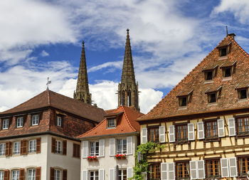 Low angle view of buildings against cloudy sky