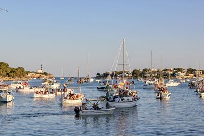 Boats in sea against clear sky