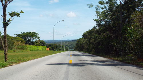 Road amidst trees against sky