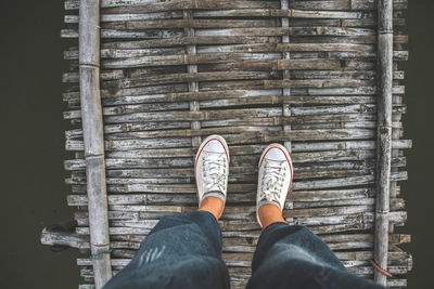 Low section of person standing on wooden floor