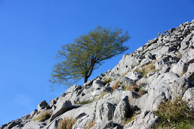 Low angle view of rock formation against clear blue sky