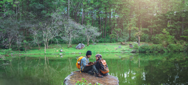 Rear view of woman sitting in lake