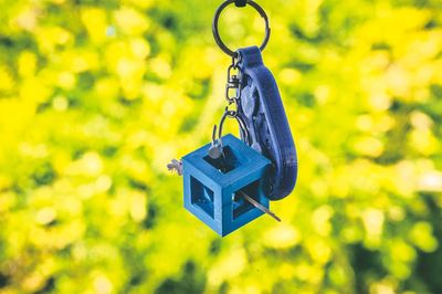 Close-up of yellow bell hanging on rope