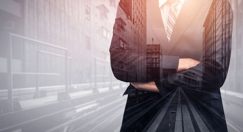 Digital composite image of man standing on city street