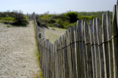 Close-up of wooden posts on beach against sky