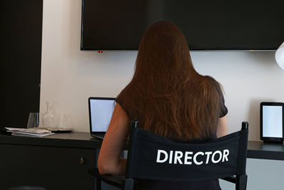 Rear view of director sitting on chair at office