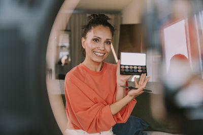 Portrait of a smiling young woman using mobile phone