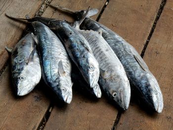 High angle view of fish on wooden table for sale in market