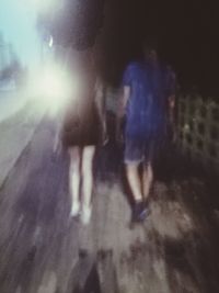 Defocused image of people walking on street at night