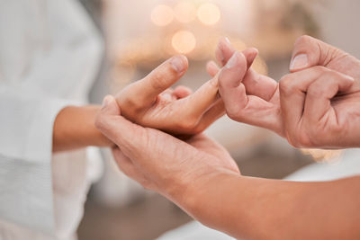 Midsection of couple holding hands