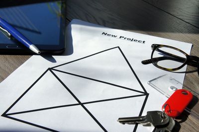 High angle view of office supplies with eyeglasses and key on table