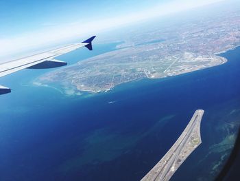 Aerial view of airplane wing over sea