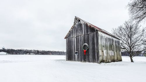 Built structure on snow covered field against sky