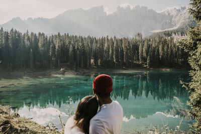 Rear view of woman on lake against mountains