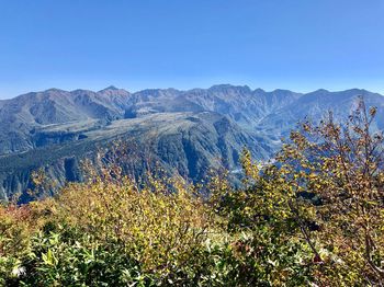 Scenic view of mountains against clear blue sky