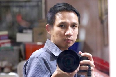 Portrait of young man holding camera