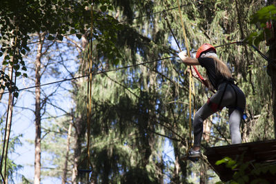 Low angle view of woman walking in forest