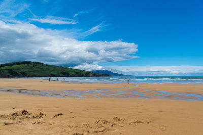 Scenic view of beach against blue sky