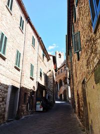 Road amidst buildings against clear sky