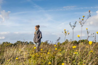 Woman standing on field against sky