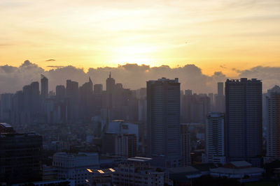 Buildings in city against sky during sunset