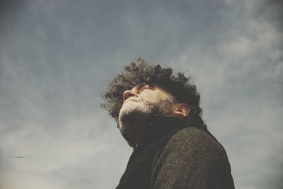 Low angle view of man looking at camera against sky