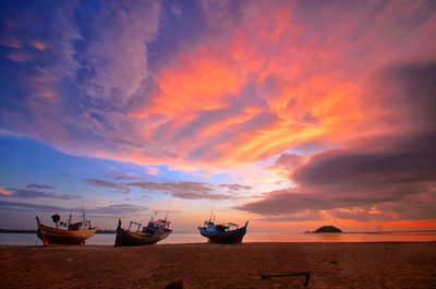 Boats moored on sea against sky during sunset