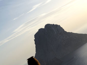 View of rock formation in cloudy sky