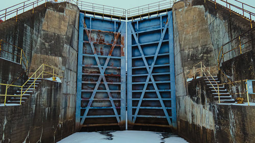 Massive dam doors in winter outside on the water surface.