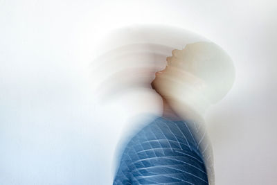 Low section of woman holding light bulb against white background